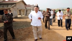FILE - In this undated photo provided on July 23, 2020, by the North Korean government, North Korean leader Kim Jong Un visits a chicken farm being built in Hwangju County, North Korea.