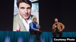 Host Chris Anderson and AI developer Tom Graham speak at TED2023 with a fake Tom Cruise on the screen, April 17, 2023, in Vancouver, British Columbia. (Gilberto Tadday/TED)