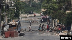 Anggota geng bersenjata berjalan di jalan dekat istana presiden, di Port-au-Prince, Haiti, 23 April 2024. (Foto: REUTERS/Ralph Tedy Erol)
