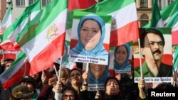 Para pengunjuk rasa memegang bendera Iran dan potret pemimpin oposisi Iran Maryam Rajavi dalam aksi protes pada hari Konferensi Keamanan Munich, di Munich, Jerman 17 Februari 2023.