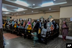 People wait inside the outpatient department at a mental health hospital in Srinagar, Indian-controlled Kashmir, on Aug 1, 2023.