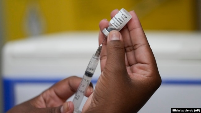 FILE - A healthcare worker prepares the Qdenga vaccine during a vaccination campaign at a health center in Rio de Janeiro, Brazil, Feb. 23, 2024. (AP Photo/Silvia Izquierdo)