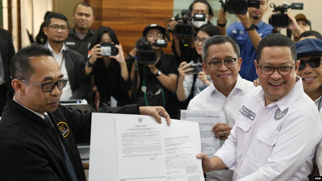 Ketua Tim Kuasa Hukum Paslon Presiden dan Wakil Presiden 01, Ari Yusuf Amir (kanan) memberikan berkas PHPU Pemilu Presiden 2024 ke perwakilan MK di Jakarta, Kamis (21/3). (VOA/IndraYoga)