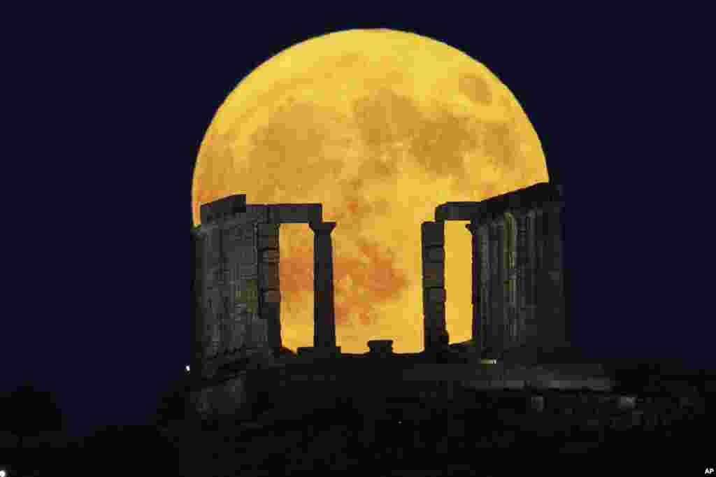 The Blue Supermoon rises behind the Temple of Poseidon at Cape Sounio, south of Athens, Greece.