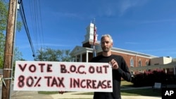Rob Romeijn protests property taxes outside Rockdale County offices in Conyers, Ga., on April 23, 2024. Romeijn says the increase in the taxable value of his house is unfair.