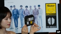 A model shows a sheet of postage stamps marking the 10th debut anniversary of K-pop band BTS at a post office in Seoul, South Korea, June 12, 2023. Post offices start selling the stamps Tuesday.