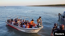 Some Rohingya Muslim refugees and Bangladeshi officials on a boat return after visiting Myanmar's Rakhine State as part of an effort to encourage their voluntary repatriation, in Teknaf, Cox's Bazar, Bangladesh, May 5, 2023. 
