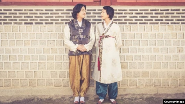 Kim Yong-min and his partner, So Seong-wook, pose in traditional Korean garments. Courtesy Kim Yong-min.