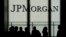 FILE - People are silhouetted under a JPMorgan Chase & Co. logo at the bank's headquarters in New York City, Oct. 21, 2013.