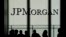 FILE - People are silhouetted under a JPMorgan Chase & Co. logo at the bank's headquarters in New York City, Oct. 21, 2013.
