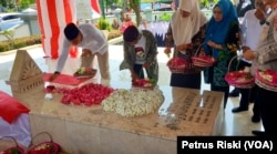 Wali Kota Surabaya Eri Cahyadi (ujung kiri kemeja putih( didampingi Soerachman (kedua dari kiri), kerabat pencipta lagu kebangsaan WR Soepratman menabur bunga di makam Pahlawan Nasional itu, di Surabaya, Jawa Timur, 9 Maret 2023. (Foto: Petrus Riski/VOA)