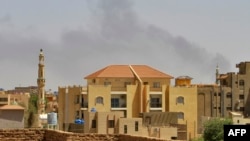Smoke rises above buildings in Khartoum on May 12, 2023, as fighting between the forces of two rival generals continues. Warplanes roared overhead as explosions rocked the city.
