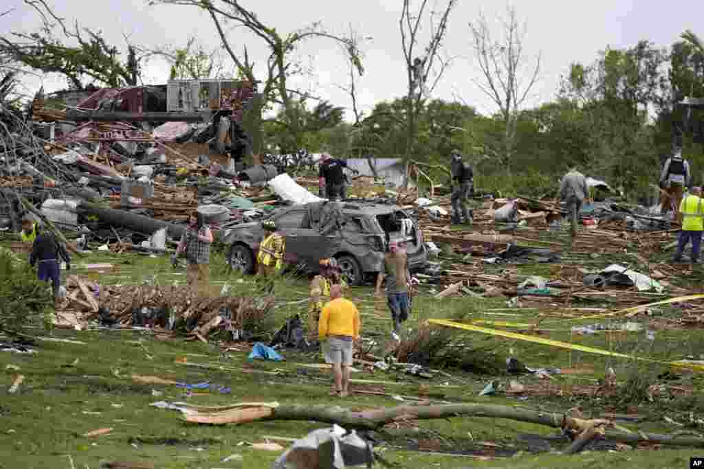 Workers search through the remains of tornado-damaged homes, May 21, 2024, in Greenfield, Iowa.