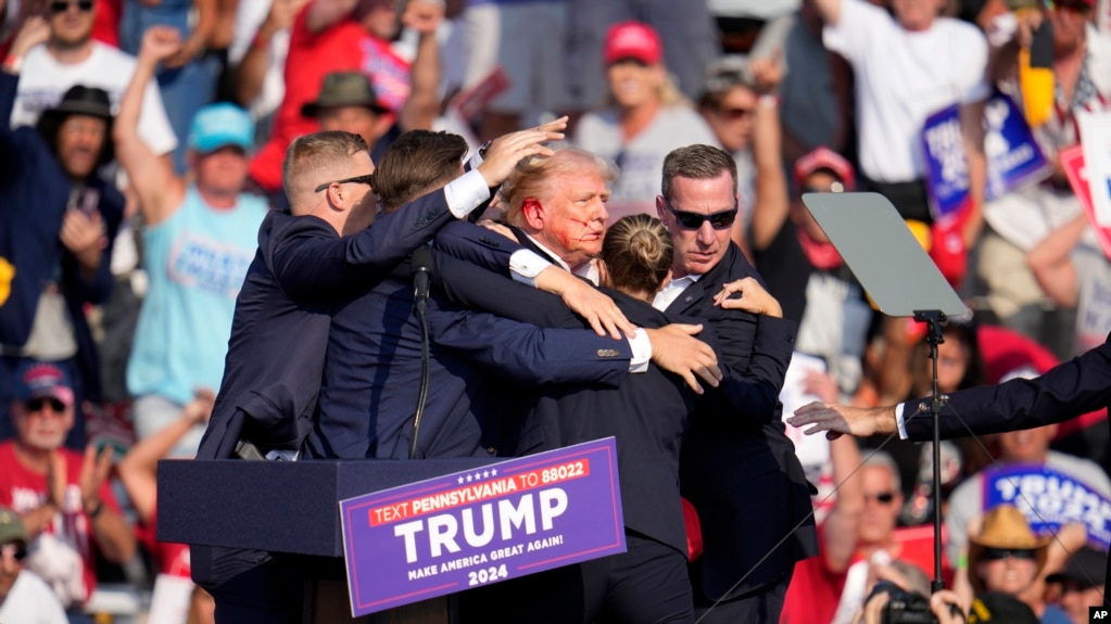 Donald Trum. El candidato presidencial republicano y expresidente Donald Trump recibe ayuda para salir del escenario en un evento de campaña en Butler, Pensilvania, el 13 de julio de 2024. (Foto: VOA).