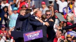 在宾夕法尼亚州的一次竞选集会发生枪击事件，安全人员帮助受伤的共和党总统候选人、前总统特朗普离开讲台。(2024年7月13日)