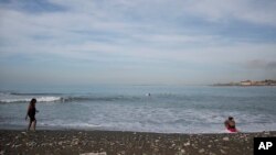 FILE - People gather on Wickie Wackie Beach in Kingston, Jamaica, Oct. 2, 2016. Deliberations over how and if to allow deep sea mining unfolded, July 15, 2024, as Jamaica-based U.N. International Seabed Authority resumed talks over a proposed mining code.