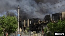 Local residents stand at a site of a Russian missile strike, amid Russia's attack on Ukraine, in Odessa, Ukraine, June 24, 2024. 