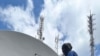 Technicians install satellite-tuning equipment at FM 93.3, the Voice of America’s new radio station serving the Karongi district of Rwanda.