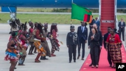 U.S. Vice President Kamala Harris, second right, is greeted by traditional dancers after landing in Lusaka, Zambia, March 31, 2023.