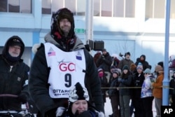 Musher Nic Petit, wearing big No. 9, makes his way down Fourth Avenue during the ceremonial start of the Iditarod Trail Sled Dog Race Saturday, March 4, 2023, in Anchorage, Alaska. (AP Photo/Mark Thiessen)