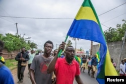 People celebrate in support of the coup leaders in a street of Port-Gentil, Gabon Aug. 30, 2023.