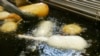资料照片：2007年8月8日，在美国印第安纳波利斯市举办的印第安纳州博览会的食品摊位上，正在使用不含反式脂肪的油煎炸糖果。（美联社照片）