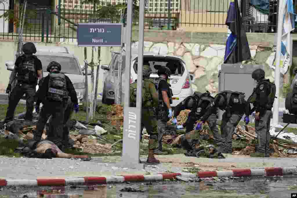 Israeli police check the bodies of militants outside the police station that was overrun by Hamas gunmen on Saturday, in Sderot, Oct.8, 2023.&nbsp;