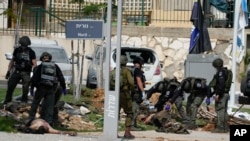 پلیس اسرائیل در کنار جنازه‌ چند فلسطینی کشته‌شده در سدروت، جنوب اسرائیل. یکشنبه ۱۶ مهر ۱۴۰۲
