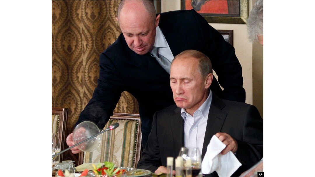 Yevgeny Prigozhin, atas, menyajikan makanan kepada Vladimir Putin di restoran Prigozhin di luar Moskow, Rusia pada 11 November 2011. (Foto: AP)