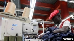 FILE - Isaac Wekesa sews a pair of denim trousers for export at the United Aryan Export Processing Zone (EPZ) factory, operating under the U.S. African Growth and Opportunity Act (AGOA), in Ruaraka district of Nairobi, Kenya on October 26, 2023. 