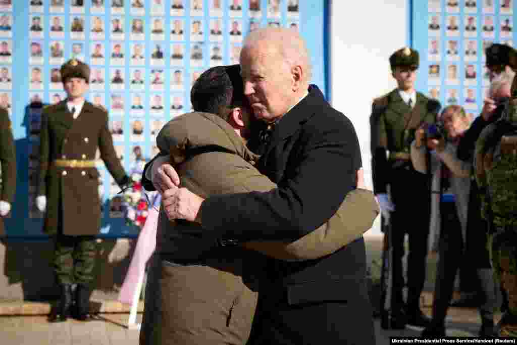 U.S. President Joe Biden embraces Ukraine's President Volodymyr Zelenskiy as they visit the Wall of Remembrance to pay tribute to killed Ukrainian soldiers, amid Russia's attack on Ukraine, in Kyiv, Feb. 20, 2023. 