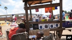 FILE - A woman sells small radio sets at a busy local marketplace stall in Harare, Zimbabwe , Feb. 2, 2023.