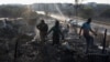 FILE - Residents rummage through the remains of their shack after a fire gutted an informal settlement in Fleurof, West of Johannesburg, South Africa in the early hours of September 3, 2023. 