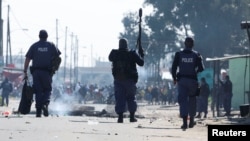 South African police officers respond during the ongoing strike by taxi operators against traffic authorities in Cape Town, South Africa, Aug. 7, 2023. 