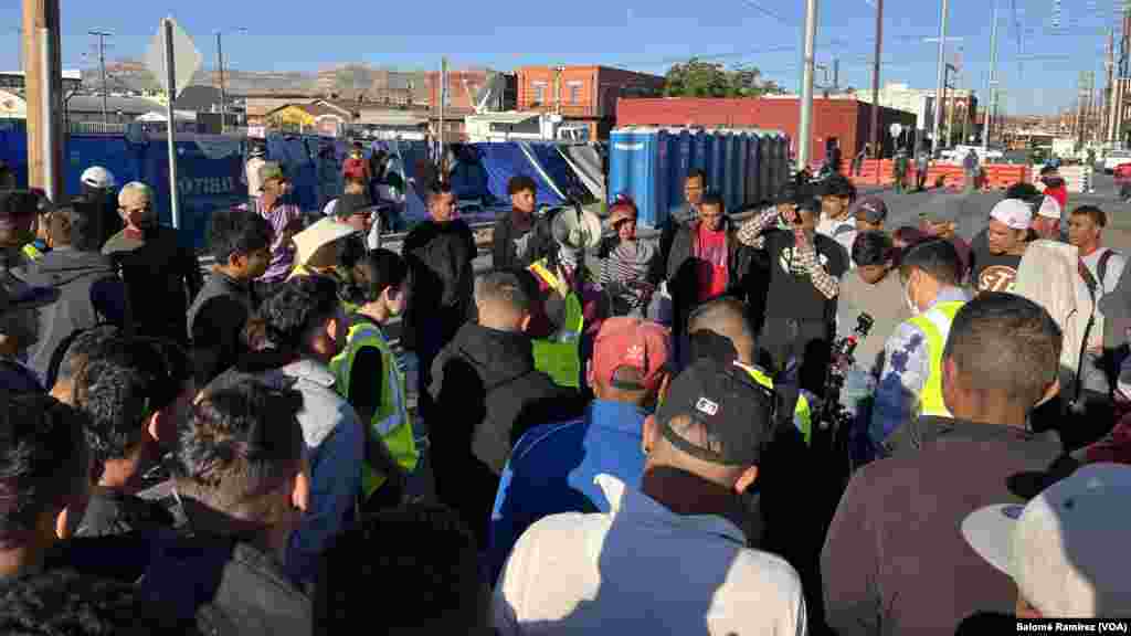 Miembros de una organización que provee asesoría legal a migrantes informan sobre los derechos que les corresponden al entrar a EEUU, en un campamento en la iglesia Sagrado Corazón de El Paso, Texas, el 8 de mayo de 2023.