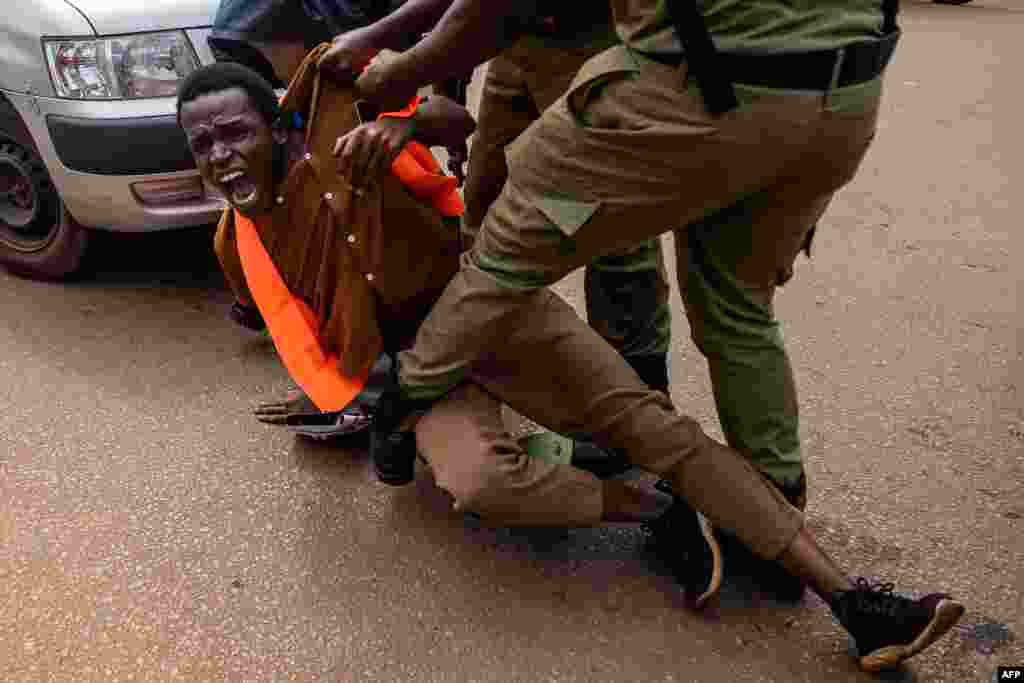 Ugandan police officers arrest an environmental activist taking part in a protest against the East African Crude Oil Pipeline Project (EACOP) in Kampala.