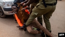 Ugandan police officers arrest an environmental activist taking part in a protest against the East African Crude Oil Pipeline Project (EACOP) in Kampala.