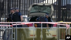 Police investigate after a car collided with the gates of Downing Street in London, May 25, 2023. 