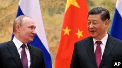 FILE - Chinese President Xi Jinping and Russian President Vladimir Putin talk to each other during their meeting in Beijing, China, on Feb. 4, 2022.