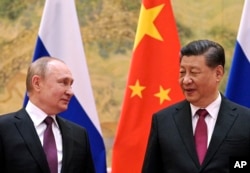 FILE - Chinese President Xi Jinping and Russian President Vladimir Putin talk to each other during their meeting in Beijing, China, on Feb. 4, 2022.