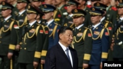 资料照：中国领导人习近平在国庆日之前向天安门广场人民纪念碑献花时走过中国军人的队伍。（2023年9月30日）