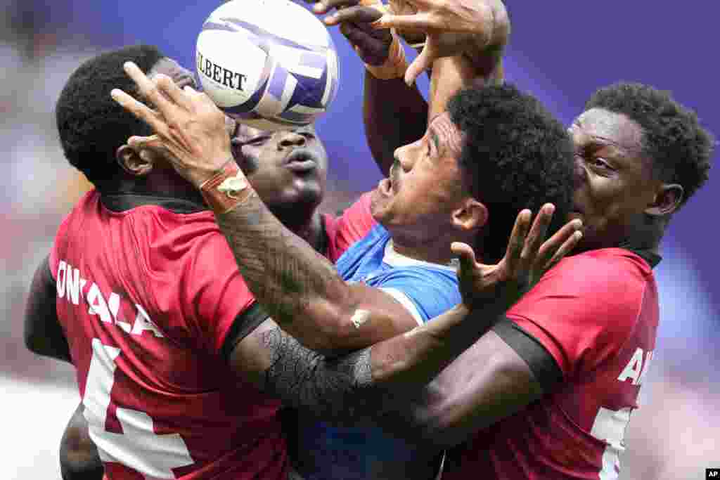 Samoa&#39;s Vaa Apelu Maliko retains the ball despite the efforts of Kenya&#39;s Vincent Onyala, left and Kenya&#39;s Nygel Pettersan Amaitsa, during the men&#39;s Rugby Sevens Pool B match between Samoa and Kenya, at the 2024 Summer Olympics, in the Stade de France, in Saint-Denis, France.