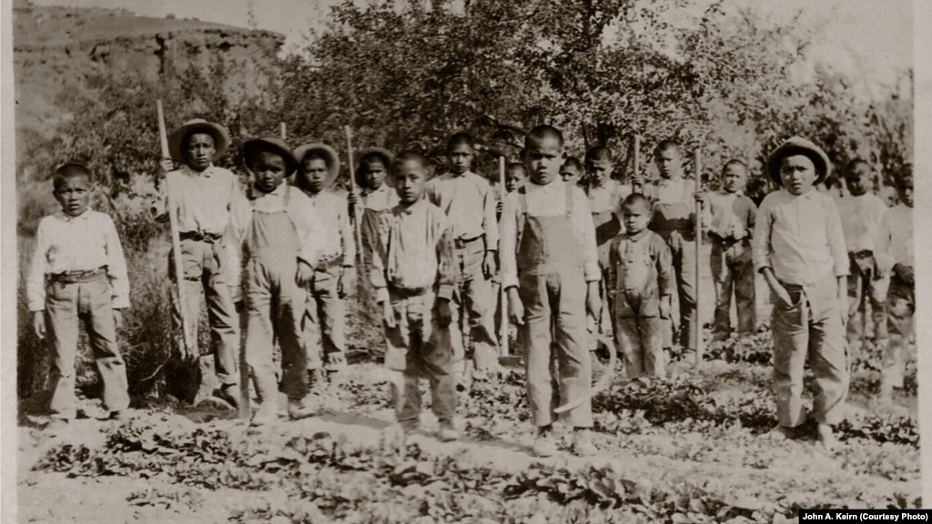 In this undated photo taken by John A. Keirn, younger school students working on school farm pose with shovels and hoes.