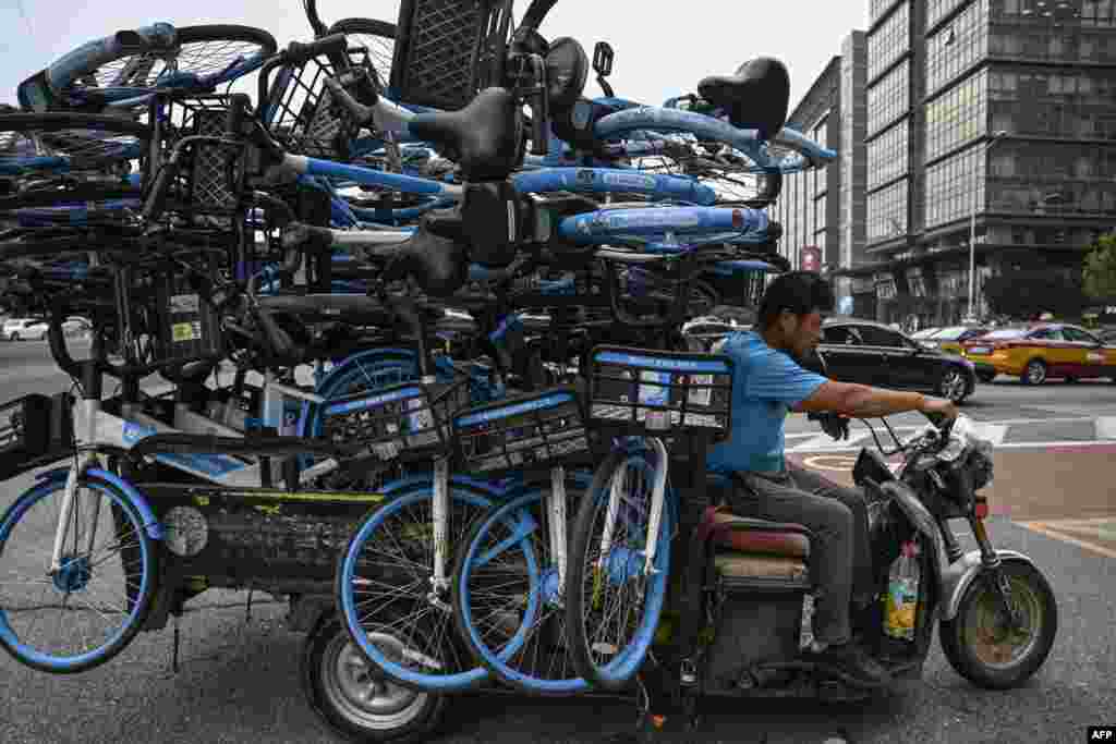 Seorang pria mengendarai sepeda motor roda tiga berisi sepeda &quot;rideshare&quot; di sebuah jalan di Beijing, China.