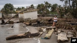 Guadalupe Cobos sits along the shore amid debris caused by flooding driven by a Gulf of Mexico sea-level rise, in her coastal community of El Bosque, in the state of Tabasco, Mexico, Nov. 29, 2023.