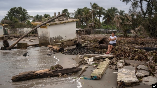 Guadalupe Cobos sits along the shore amid debris caused by flooding driven by a Gulf of Mexico sea-level rise, in her coastal community of El Bosque, in the state of Tabasco, Mexico, Nov. 29, 2023.