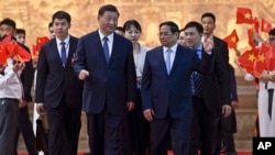 Vietnam's Prime Minister Pham Minh Chinh, center right, talks to China's President Xi Jinping, center left, after their meeting at the Government Office in Hanoi, Dec. 13, 2023.