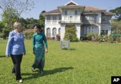 FILE - Pemimpin oposisi pro-demokrasi Myanmar Aung San Suu Kyi (kanan), dan Menteri Luar Negeri AS Hillary Rodham Clinton berjalan melewati taman setelah pertemuan di kediaman Suu Kyi di Yangon, Myanmar, 2 Desember 2011. (Saul Loeb/Pool via AP)