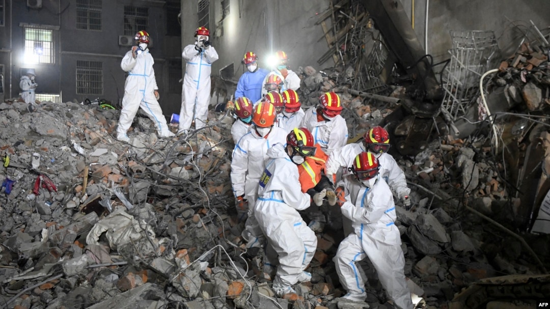 FILE - This photo taken early on May 5, 2022 shows rescuers carrying a survivor out of a collapsed six-story building in Changsha, central China's Hunan province. (Photo by CNS / AFP)