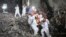 FILE - This photo taken early on May 5, 2022 shows rescuers carrying a survivor out of a collapsed six-story building in Changsha, central China's Hunan province. (Photo by CNS / AFP)